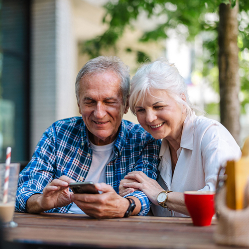 Elderly couple looking at smart phone screen together